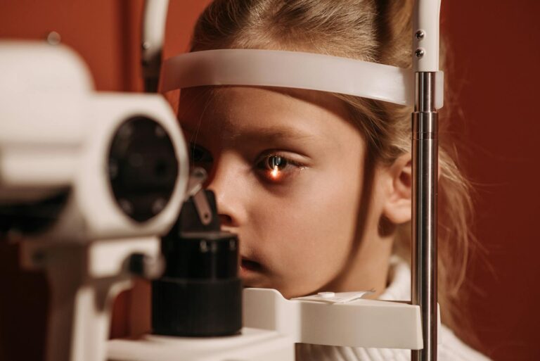 A young girl undergoing an eye exam with advanced ophthalmology equipment, focusing on vision care.